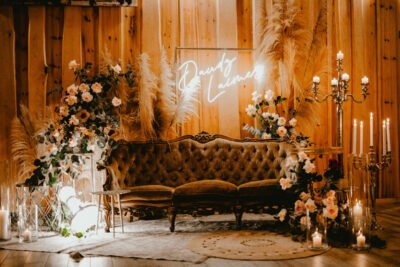 Warm white LED neon sign above a vintage sofa at a wedding photo zone