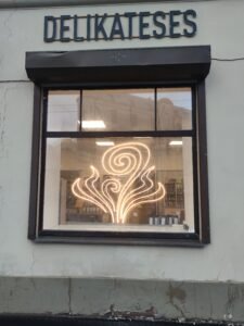 Warm white decorative LED neon swirl sign in a shop window