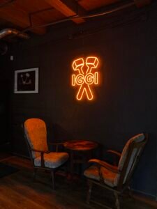 Orange LED neon logo sign on a dark café wall