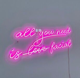 Pink LED neon sign "all you need is facial" for a beauty salon