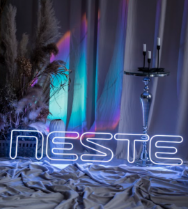 White "Neste" LED neon logo sign at a corporate event