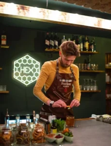 White hexagon "HEX" LED neon logo sign behind a cocktail bar