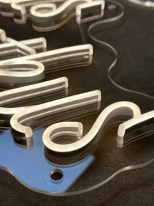 Close-up of white LED neon tube letters on clear acrylic