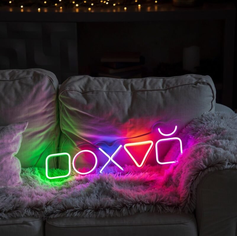 Multicolour controller button icons LED neon sign on a sofa