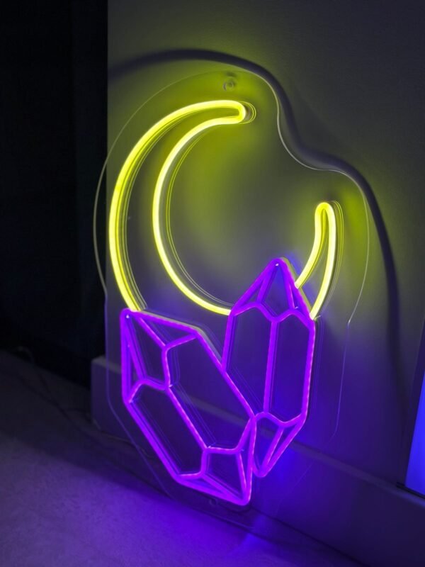 Yellow moon and purple crystals LED neon sign glowing on a bedroom wall