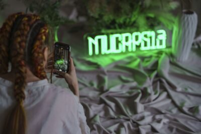 Green LED neon sign being photographed with a smartphone at a photo shoot